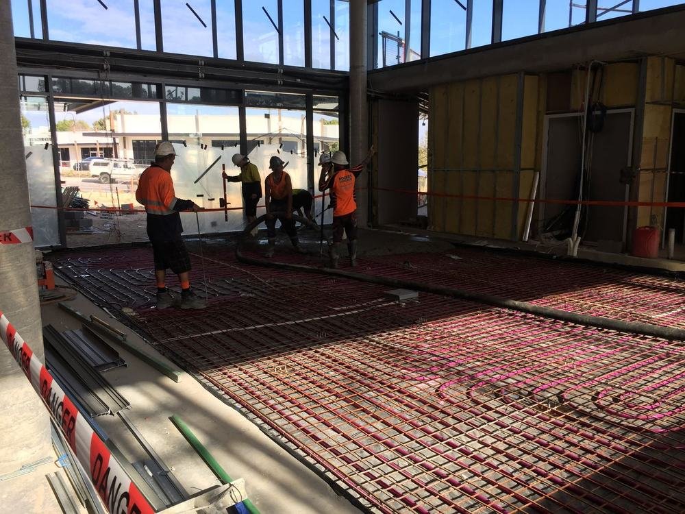 Euroheat crew laying a hydronic pipe grid across a concrete slab