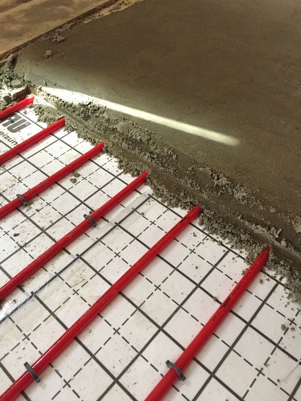 REHAU hydronic pipe clipped to insulation panel and being embedded in screed – slab detailing