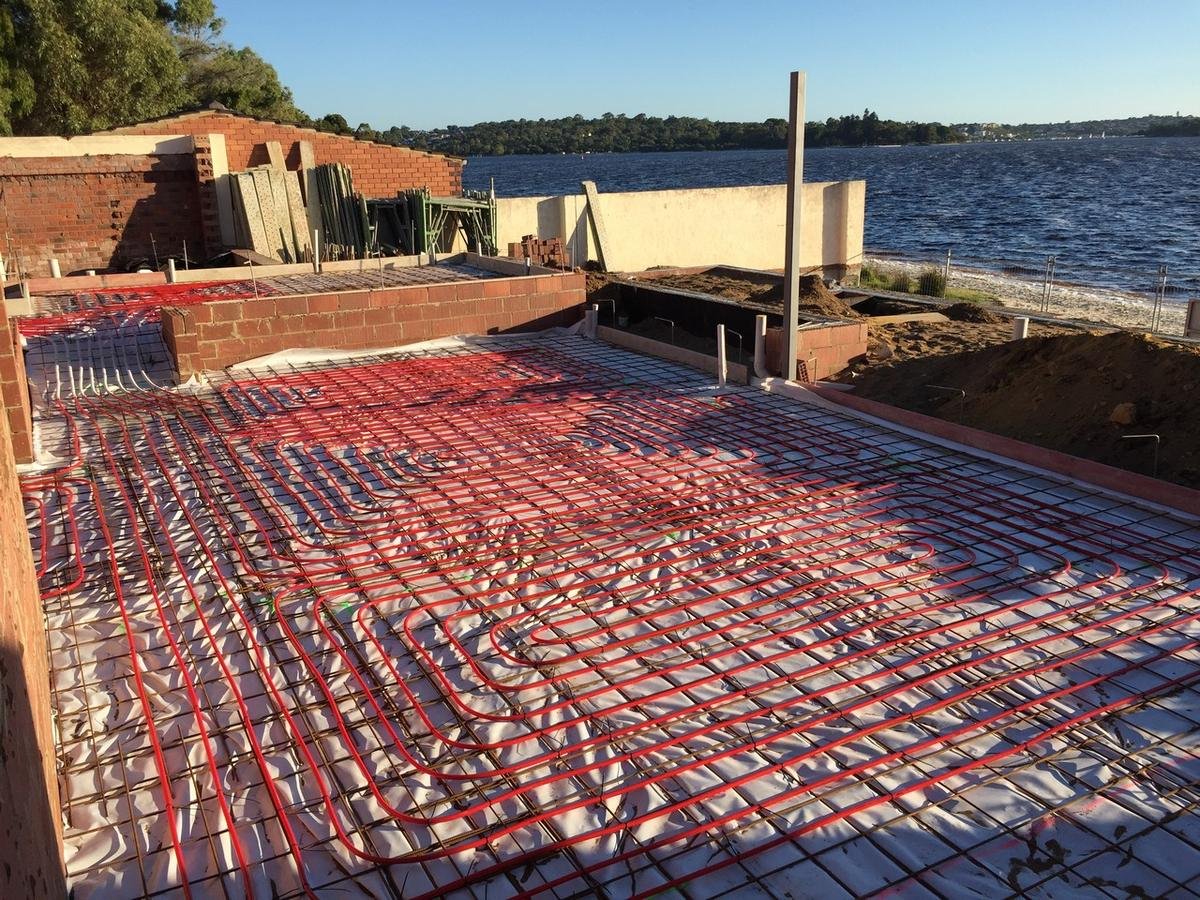 Hydronic pipe loops laid across a riverside slab before the concrete pour, Perth